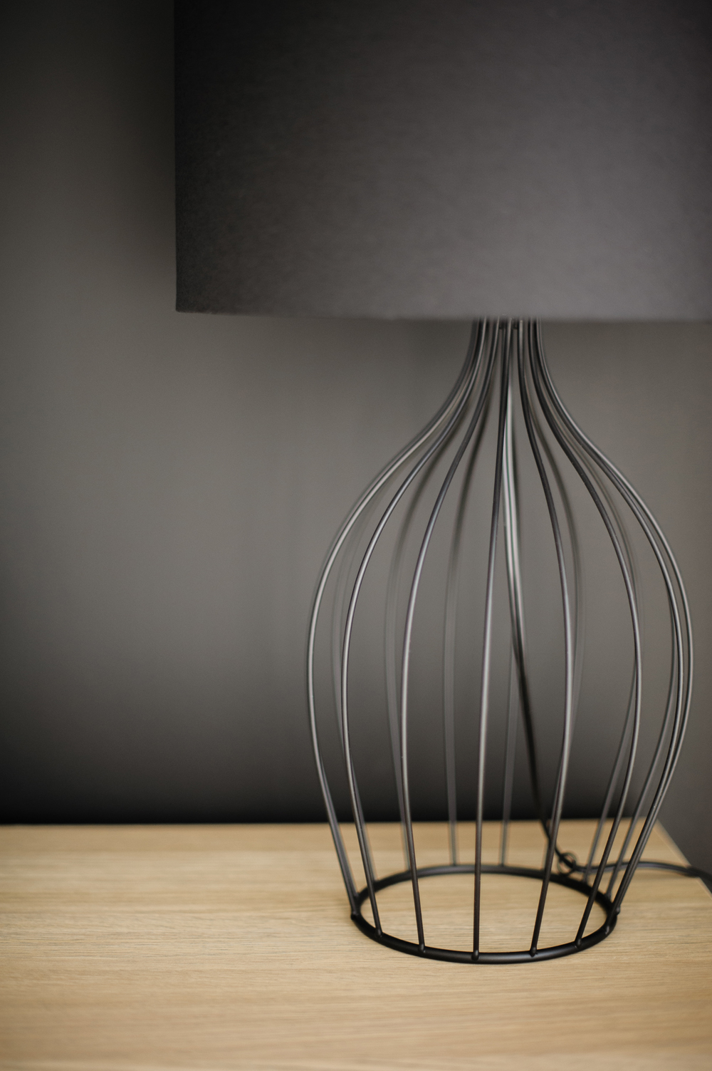 Barely There Lighting Black wire table lamp against a black wall