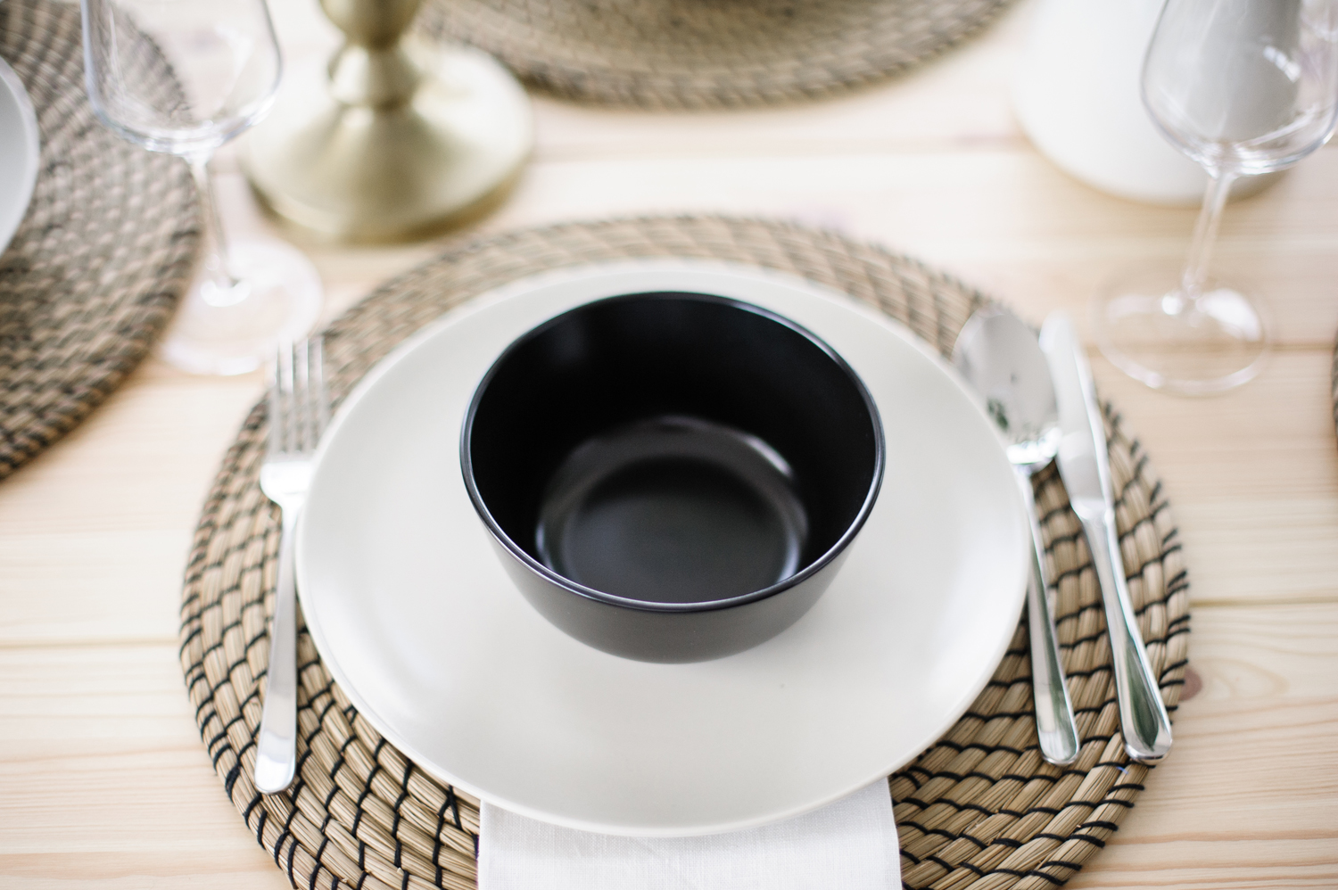 Mixed Materials Table setting with woven charger and black bowl