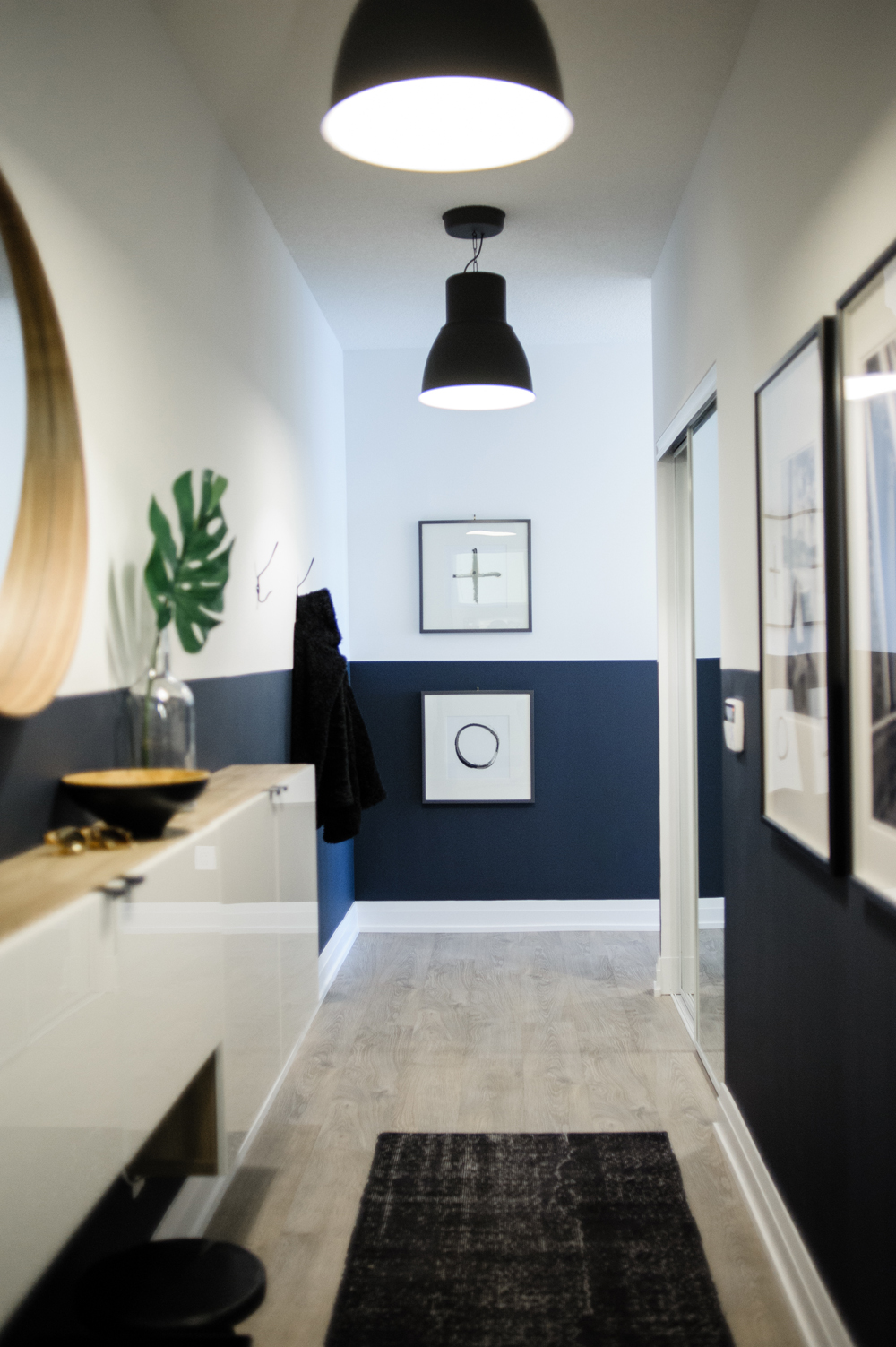 Where Style Meets Function Long condo entryway with navy blue lower half walls