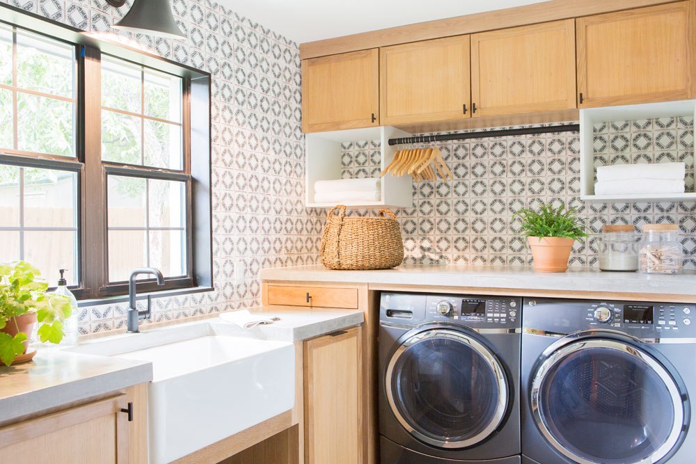 Farmhouse Flair Modern farmhouse laundry room design with patterned backsplash and wooden cabinetry.