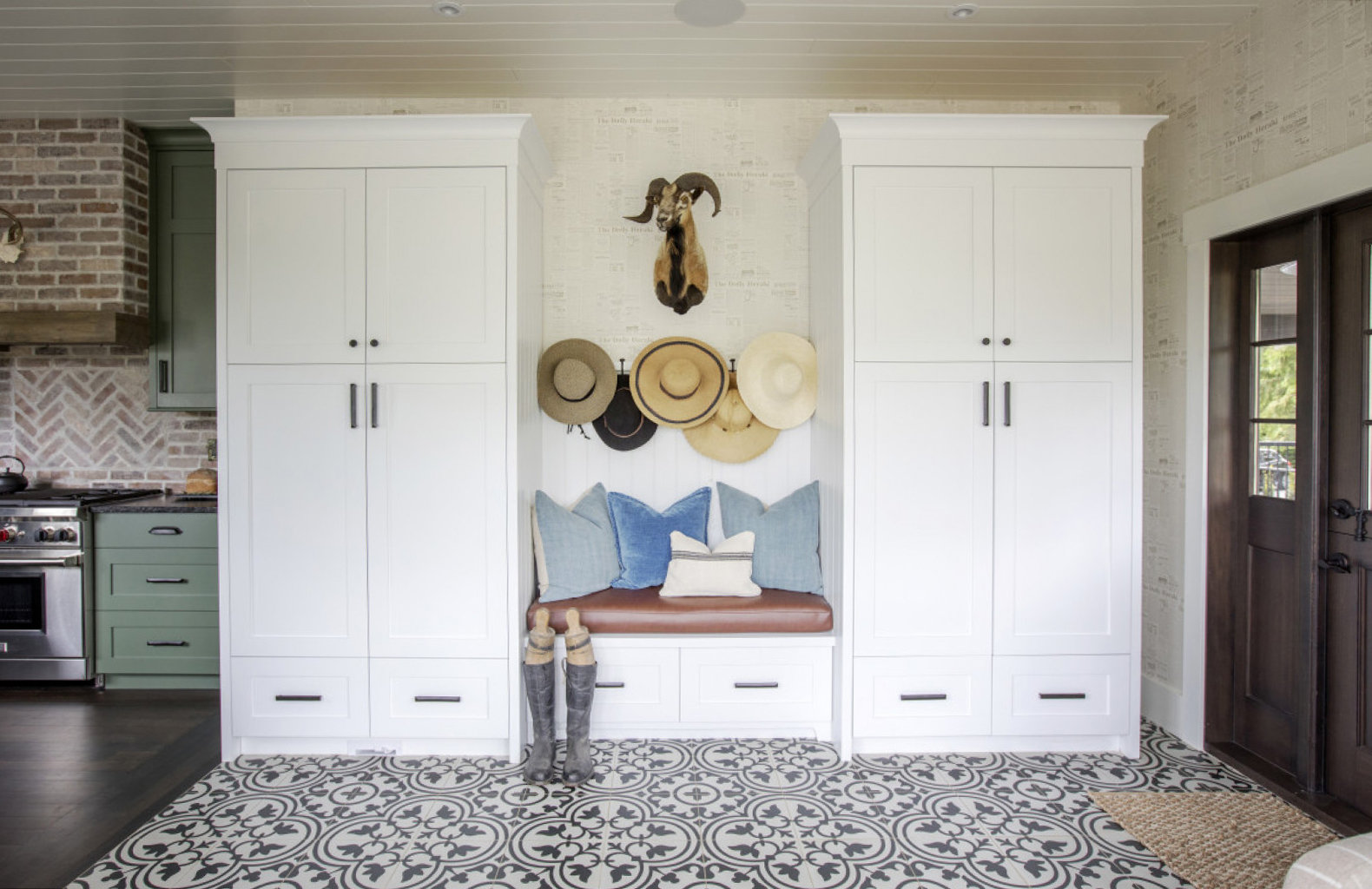 Prints Charming Mudroom, bench flanked by white cabinets, black and white patterned tile floor