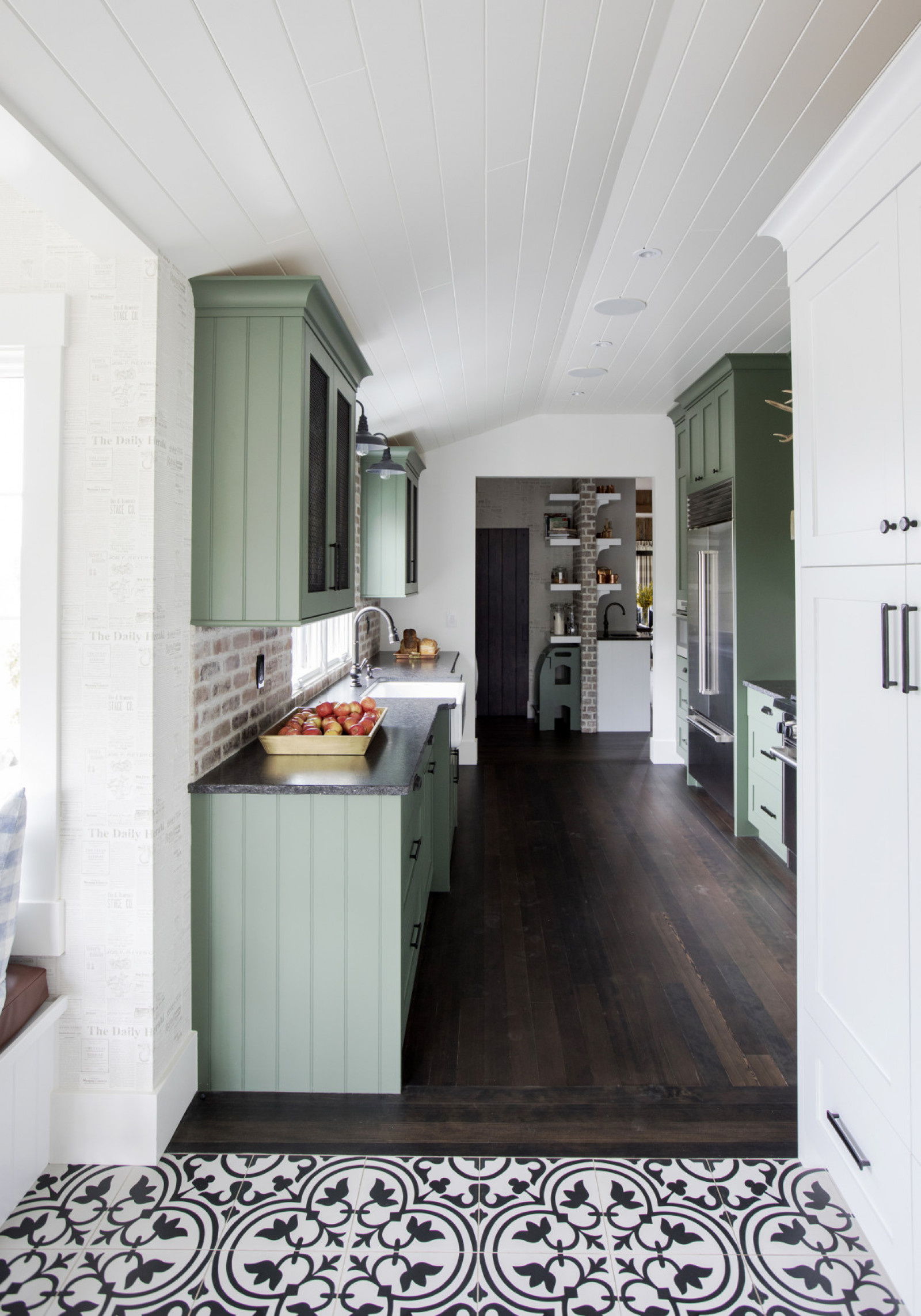 Green Energy gallery kitchen with avocado green cabients, dark wood floor, white and black tile in foreground