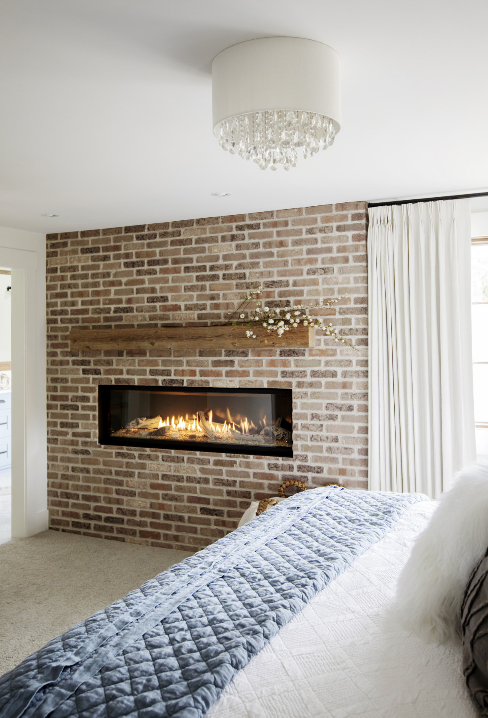 Comfy Cozy exposed brick wall with gas fireplace in bedroom