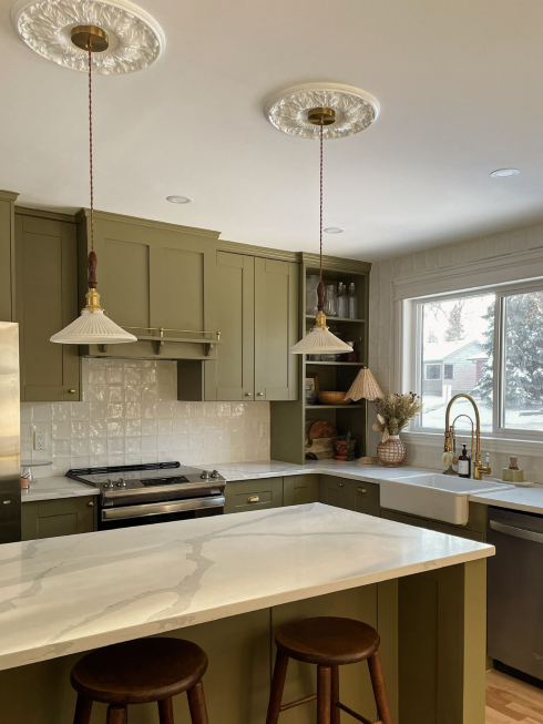 Dream Kitchen A kitchen with green cabinets, quartz countertops and two pendant lights
