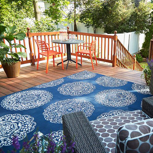 Rotate Your Rug Regularly blue outdoor patterned rug with orange chairs outside backyard summer fiddle leaf fig plant