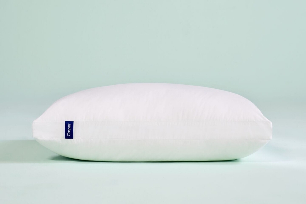 The Best Pillow for Neck Pain as a Side Sleeper A Casper pillow in a mint blue background.