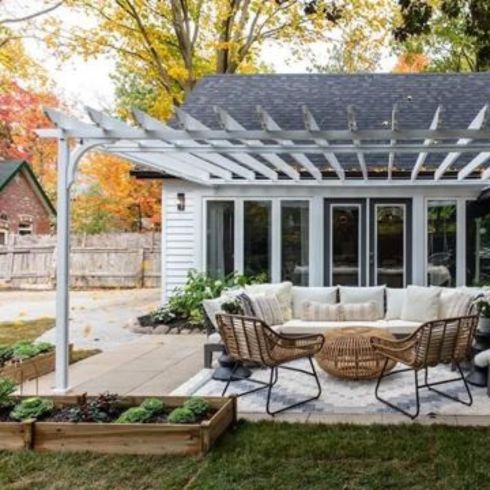 Mistake #9: Not Changing the Elevation Modern backyard with white pergola, modern furniture and elevated furniture.