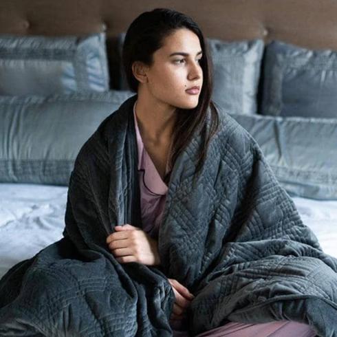 Hush Woman in bed with duvet cover over her.
