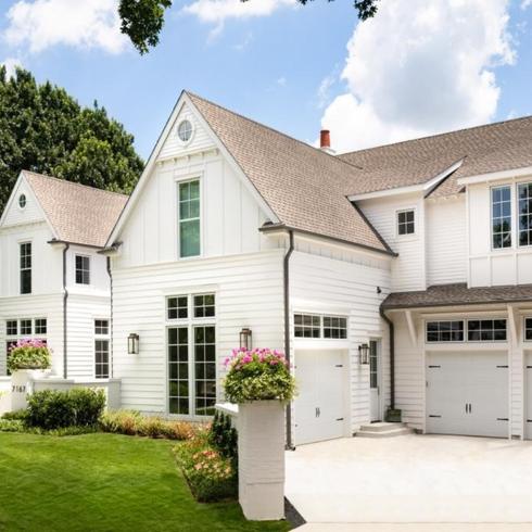 Increase Your Home’s ROI with a New Garage and Additional Parking White house with a three-car garage and large driveway
