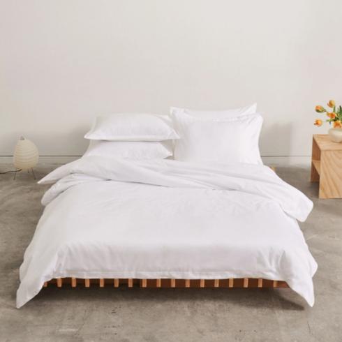 Kotn White bed sheets in a white bed.