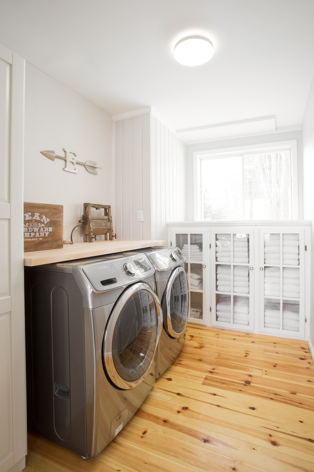 Light-Filled Living light-filled laundry room with warm wood floors and storage.