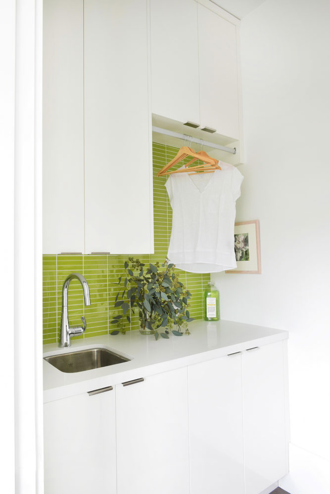 Beachy Clean Small laundry room with lime green glass tile backsplash.