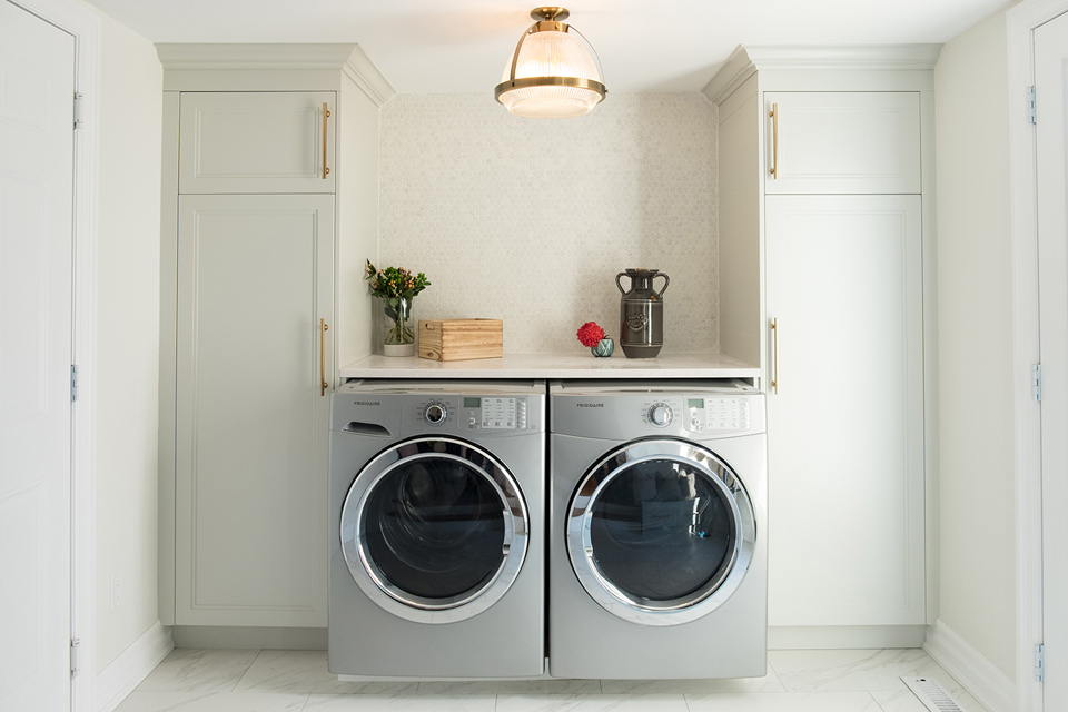 Practically Speaking Small laundry space with floor-to-ceiling cabinets and a folding surface.