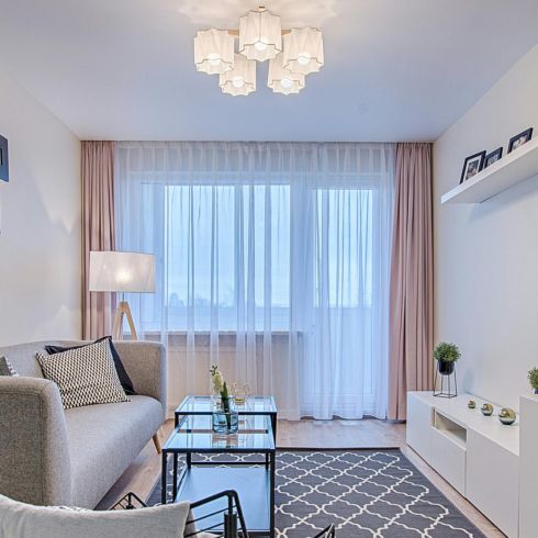 Light It Up A bright living room with sheer white and pink drapes in a large window.