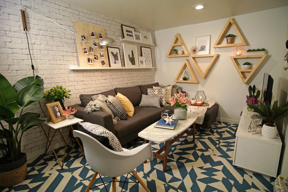 Geometry Lessons basement with one painted white brick wall blue and white patterned rug and wooden triangles on wall