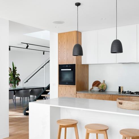 High-End Upgrades A modern kitchen with sleek high-end finishes and black pendant lights