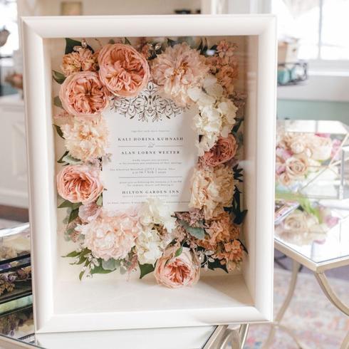 Frame Your Wedding Invitation A memory box filled with flowers and a wedding invitation.