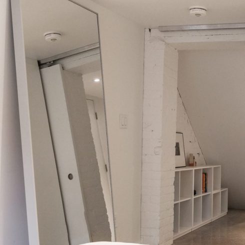 Mirrors A basement bedroom with a large floor-to-ceiling mirror