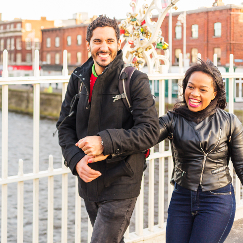 Dublin, Ireland A smiling man and a woman walk arm in arm across the Ha'penny Bridge in Dublin, Ireland.