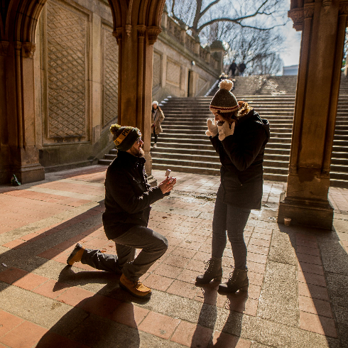 New York, United States A man on one knee proposing marriage to a woman at Bethesda Terrace in Central Park, New York City