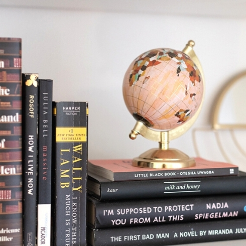 Avoid Overcrowded Bookshelves Pink globe and black books on a white bookshelf