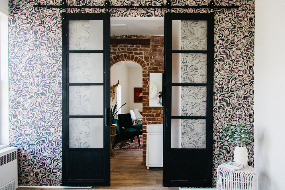 Overly-Stylized Decor Bold wallpaper and sliding doors leading into the living area