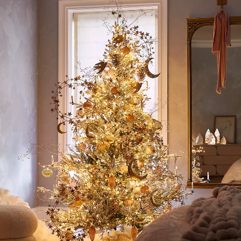 Glam and Glitzy A faux snowy-looking artificial Christmas tree with golden twinkle lights