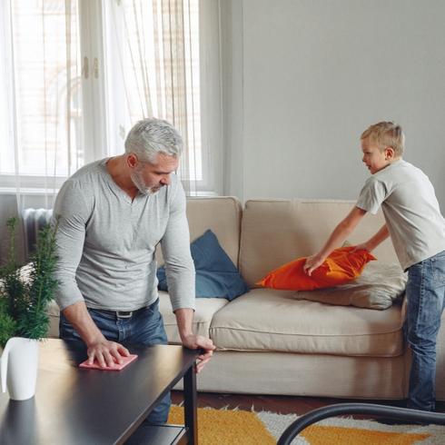 Fastest Way to Clean Your House A dad and son cleaning living room rogether