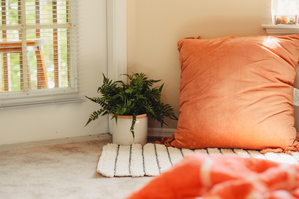 Floor Space orange floor pillow and white rug