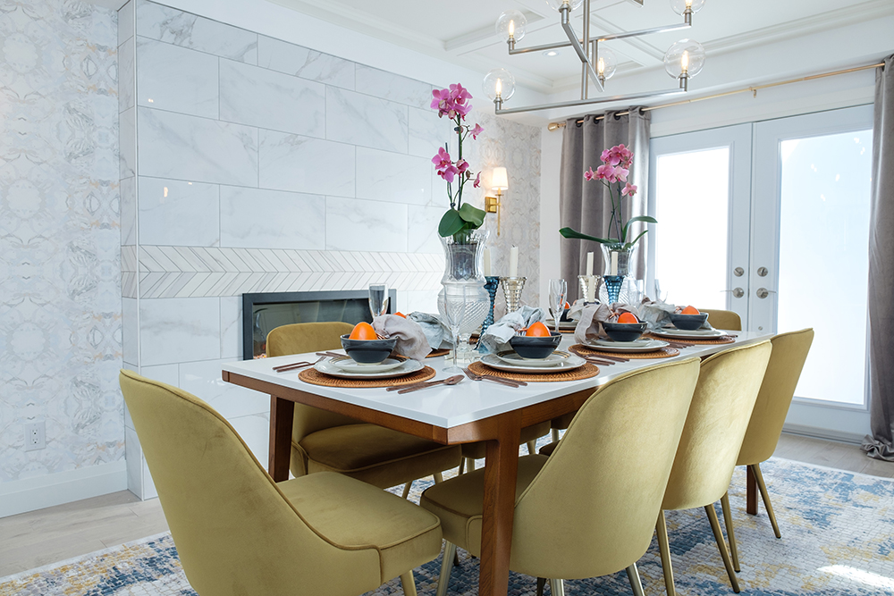 Orchids Thrive in High Humidity Dining room table with gold chairs around it. Two orchids sit in vases on top of the table.