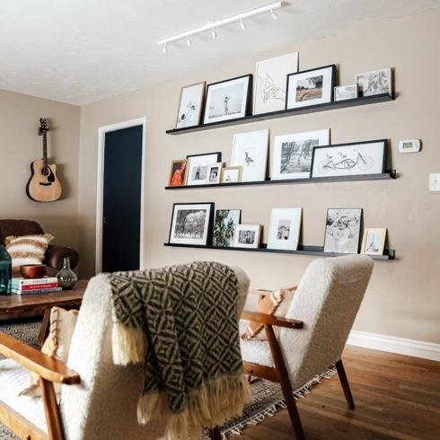 Place the Photos on a Shelf A photo ledge mounted on the wall with several different frames.