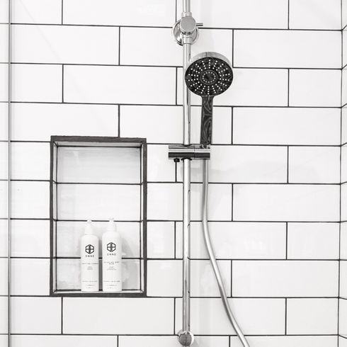 10. Clean Your Showerhead With Vinegar a shower with white tiles and a clean showerhead