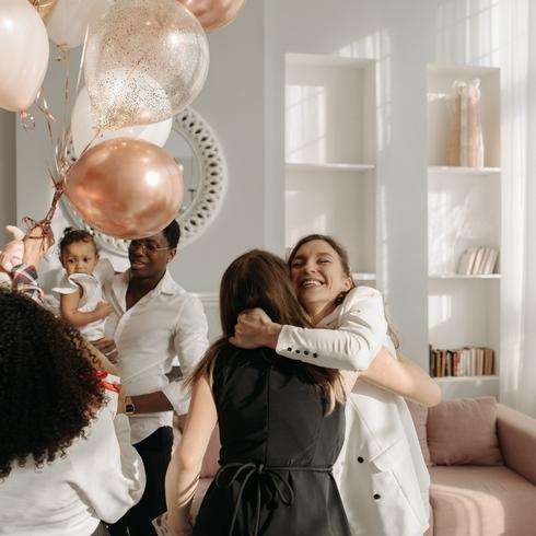 You Don’t Make Introductions Friends hugging one another at a party