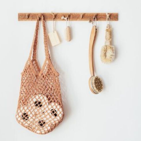 Hook it Up wooden hooks with bag and loofahs on white wall