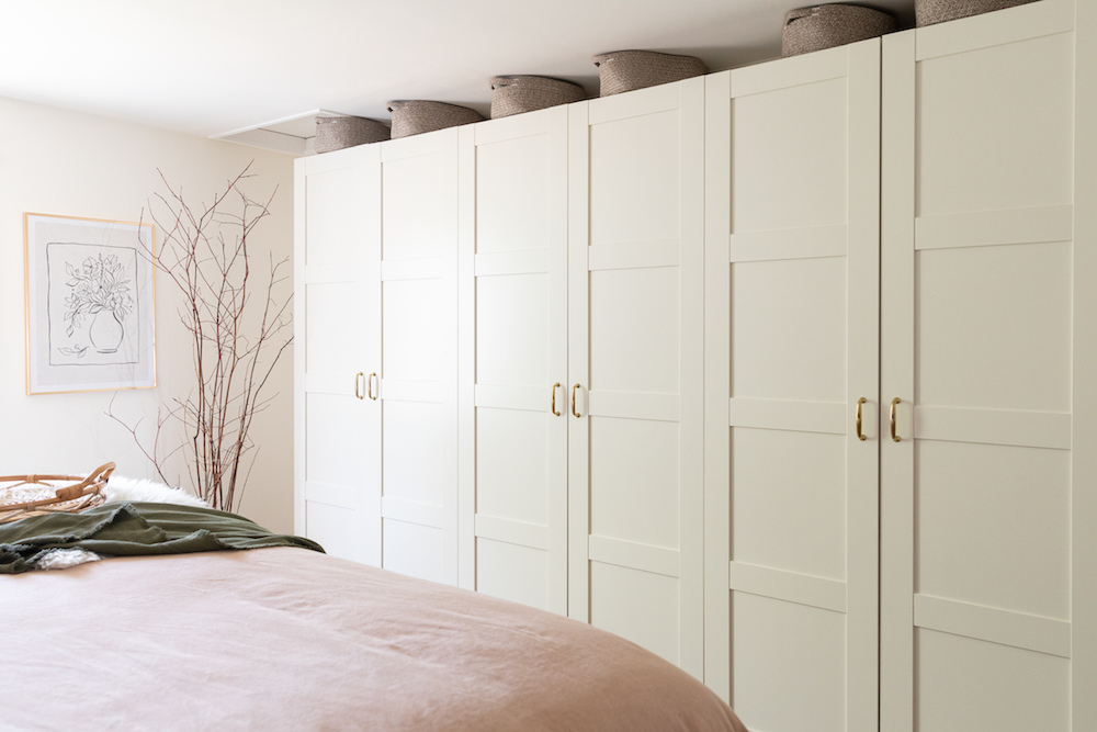 Build it In row of tall white cabinets in cozy bedroom