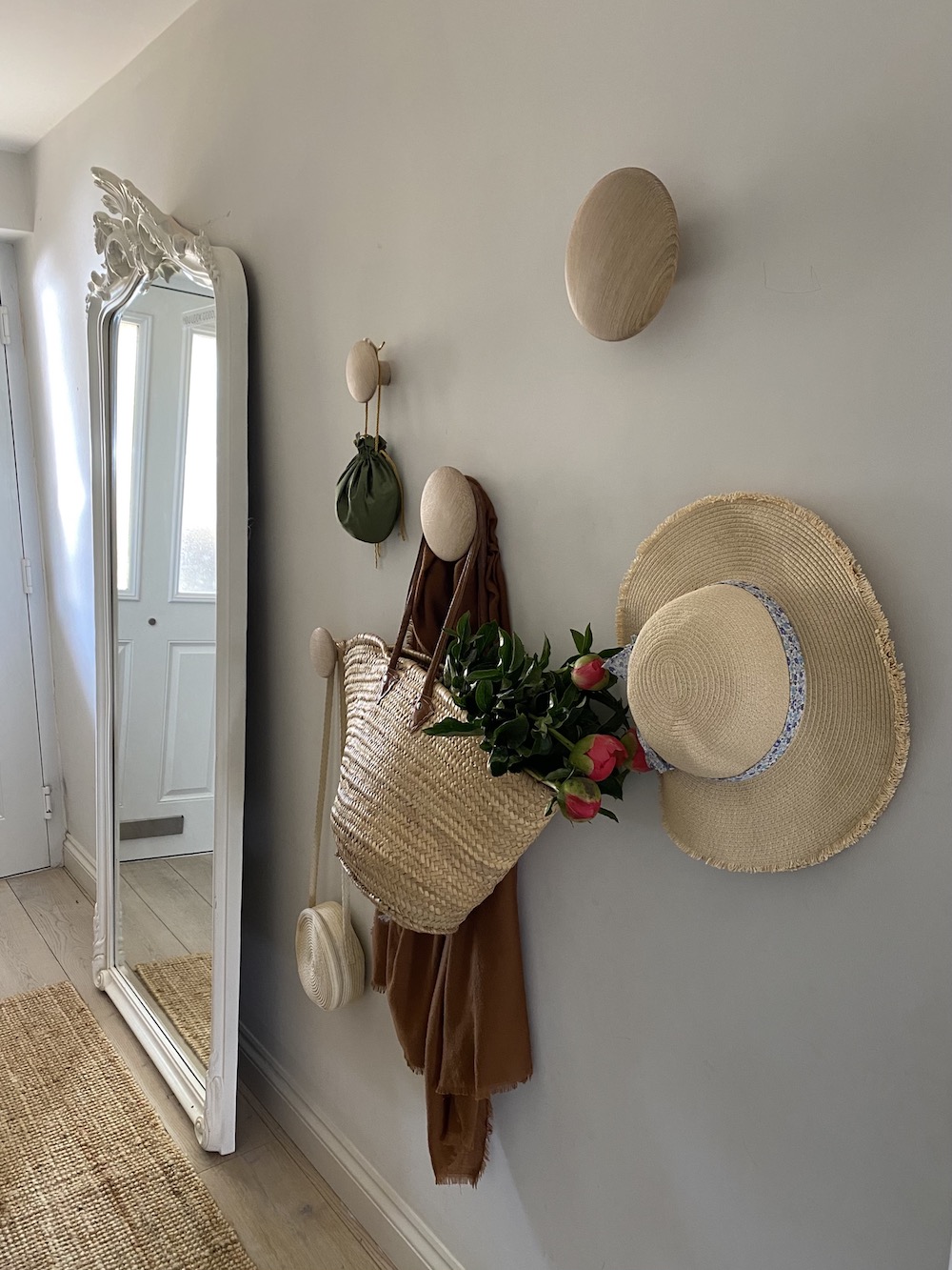 Affix Stylish Pegs Pegs and a standing mirror in a hallway with a sisal runner
