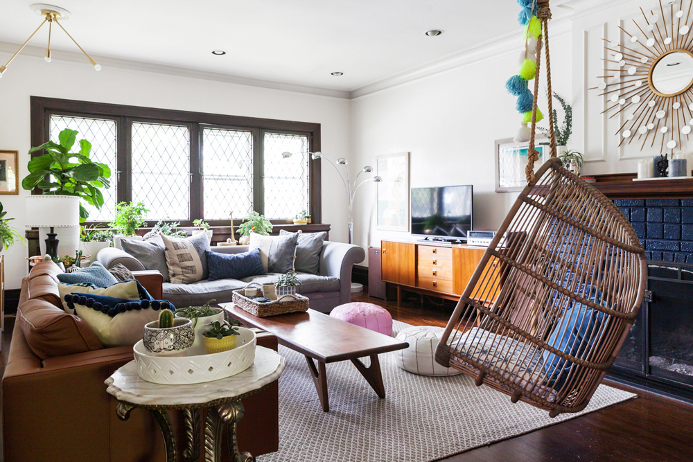 Let the Sunshine In A brightly lit living room with two couches, plenty of throw pillows and a wicker swing