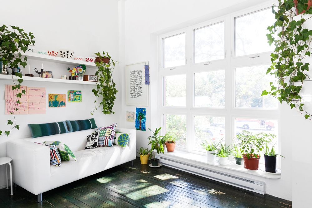 Greenhouse Effect A pristine white living room with plenty of natural light and potted plants