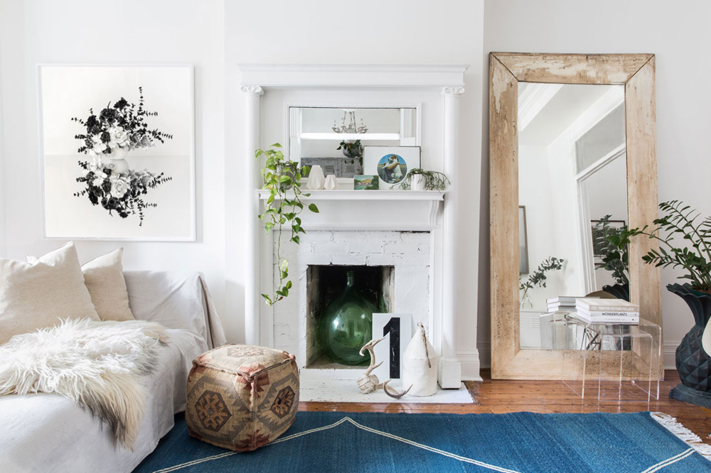 Flashes of Colour White living room with old brick fireplace and large wood mirror