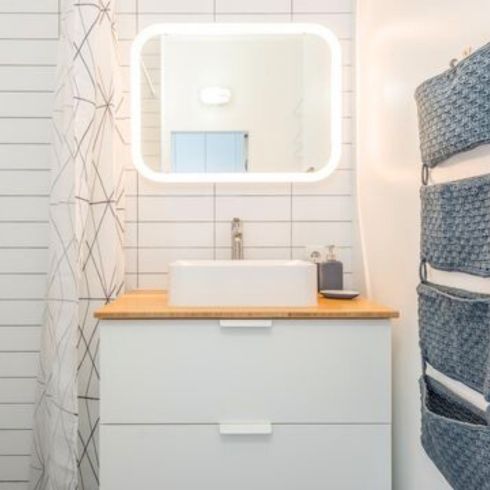 Hang Time modern white bathroom with lighted mirror and tiered hanging storage piece