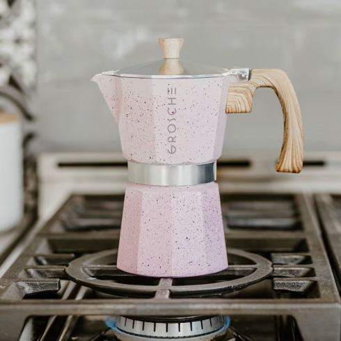 A Pink Terrazzo Espresso Maker A blush pink stovetop espresso maker on a gas stove