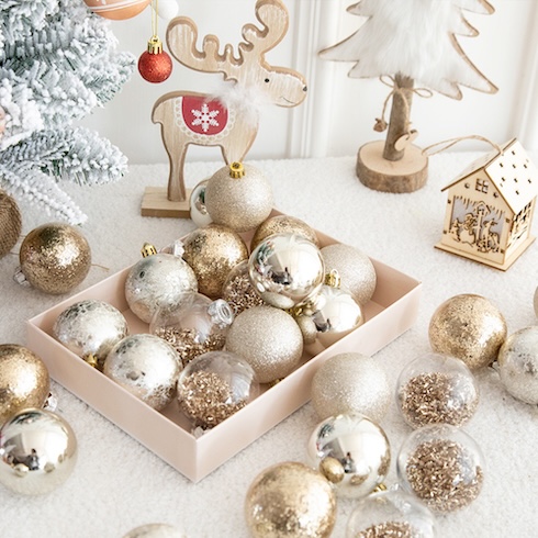 Start with a Plan An assortment of elegant metallic round ornaments set in and around a rectangle tray on a festive table.