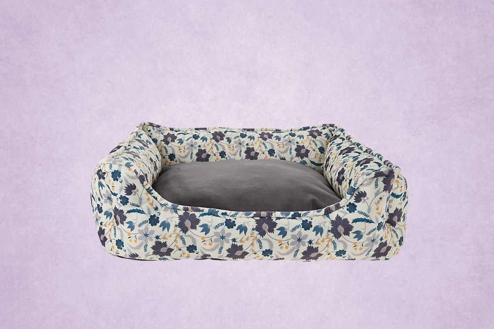Grandmillennial A navy and gray floral dog bed on a purple background
