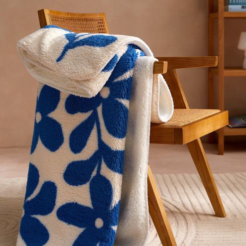 Graphic Flowers Fleece Throw Blanket Blue and white graphic flower throw blanket on arm of wooden chair