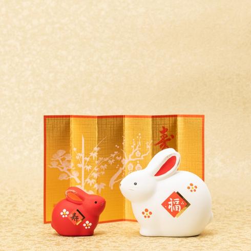The New Year’s Animal Two rabbits in front of a lunar new year decoration.