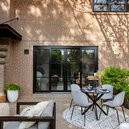 Mistake #4: Not Being Strategic With Furniture Size Small backyard with small dining table and grey chairs, along with comfy lounge chair and plants.