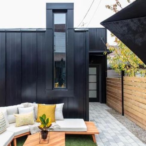Mistake #8: Over Accessorizing Small backyard with modern furniture and black modern shed.
