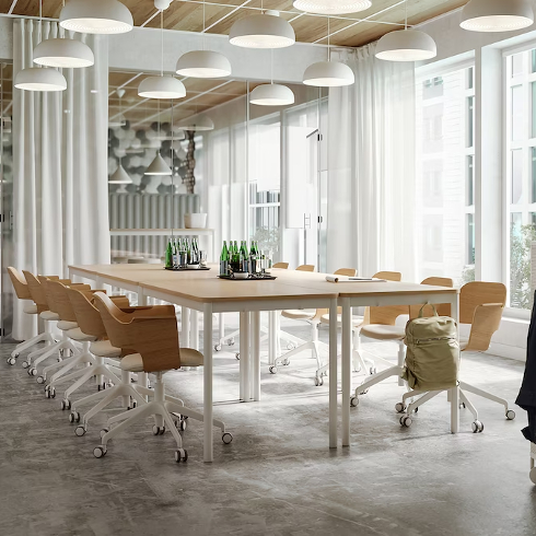 Dining Desk A wooden topped desk with many office chairs around it