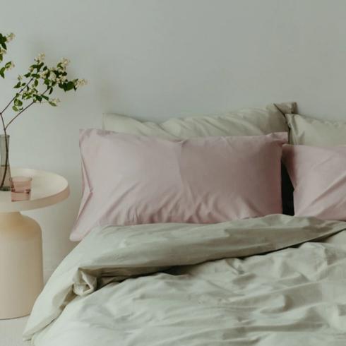 Tuck Bedding Sage green bedding in a bedroom.