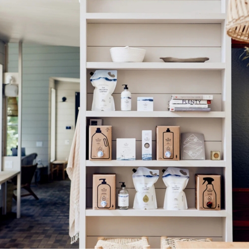 The Unscented Company Soap in bottles and refill cartons from unscented company featured on shelves in a rustic room.